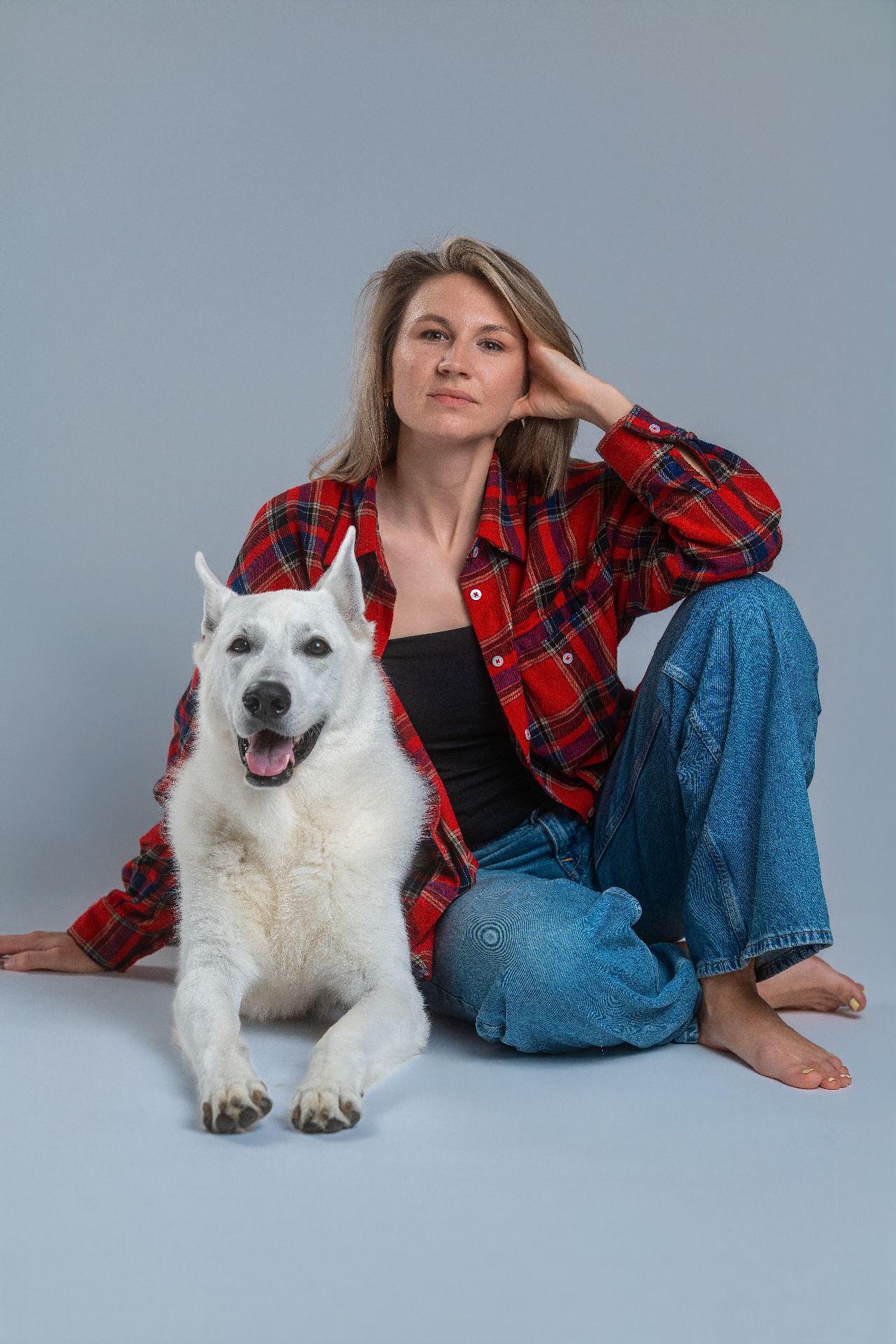Anastasiia with a focused white German Shepherd — professional dog trainer portrait